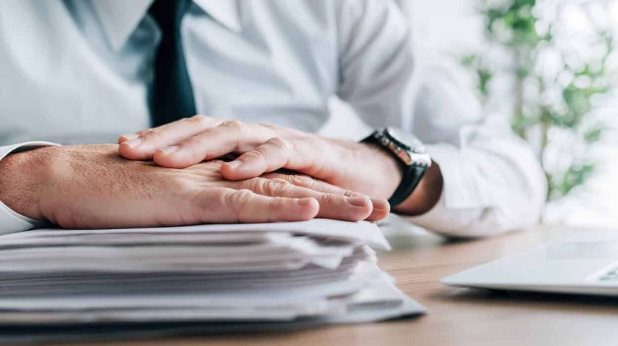 Insurance agent with stack of policy contracts on office desk