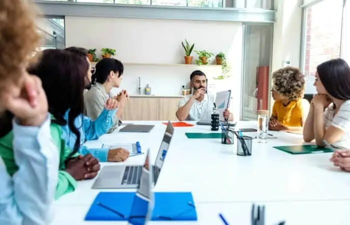 Multiracial employees listen to indian boss in company meeting. Copy space.